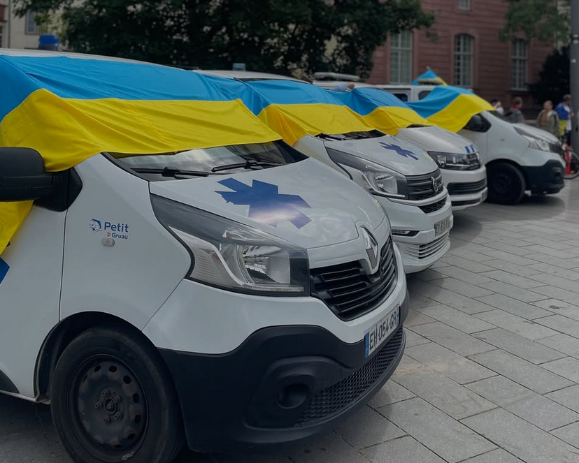 Колона авто швидкої допомоги під українськими прапорами